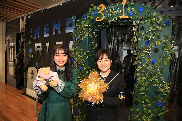 3年1組の謎解きゲーム「Memories」の前で。右が村田さん。