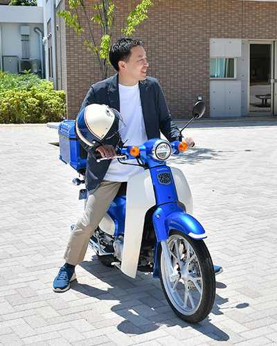愛用のバイクで通勤する高井先生