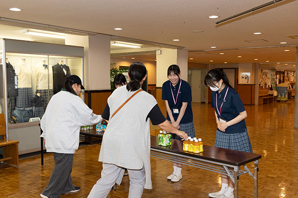 冷たい飲料水を用意して迎えてくれる生徒たち。「暑いなか、ようこそお越しくださいました」と一礼する姿に、玉聖らしいおもてなしの心が表れています。