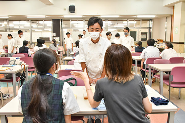 食事会の合間を縫って在校生に質問する受験生親子