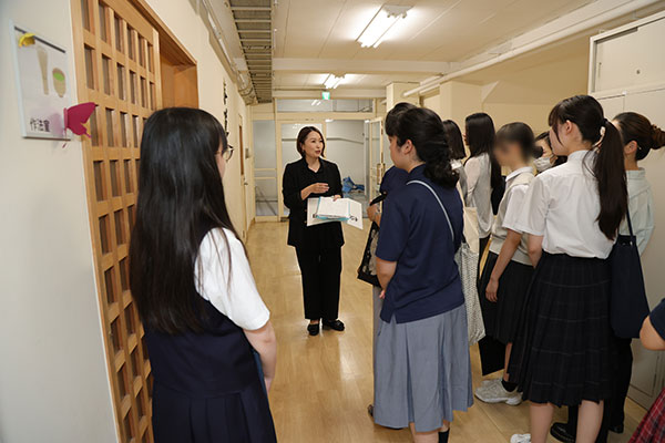 校舎見学は10名ほどのグループに分かれて実施。生徒は最後部に付き、補足説明や質問に対応します。