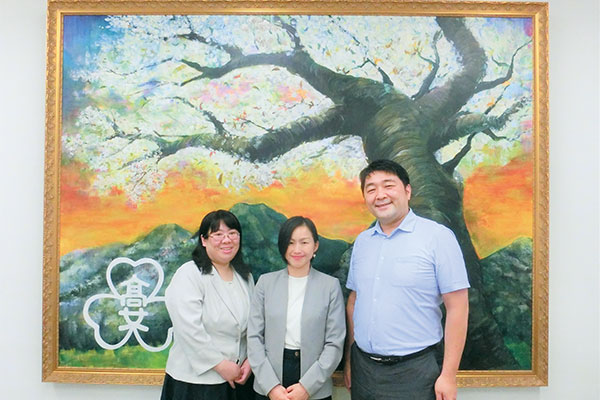 左から、芝辻先生、田中先生、山口先生。90周年記念あかつき祭で美術部が制作した巨大な作品の前で。