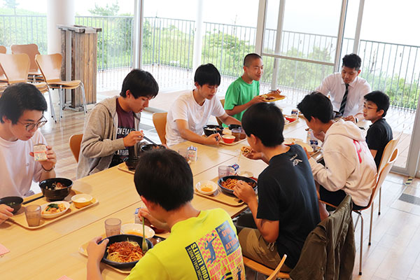 コロナ禍以前の食事の様子。コロナ禍においては3学年ずつに2分割の上、1人1テーブルの黙食を徹底している