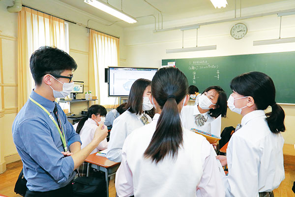 中1の授業での一場面。「海と陸地の理想の比率」について話し合う生徒を見守ります。