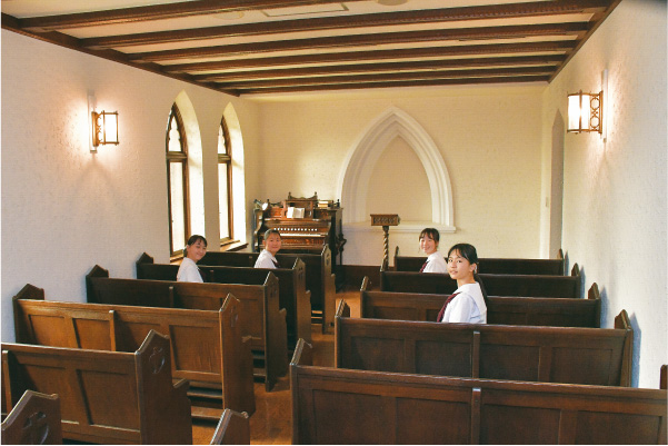 ヴォーリズのデザインを活かし、長イスや和ガラスなど、旧校舎のものを再利用した「メモリアルチャペル」。高校生のクラス礼拝、宗教活動委員会の活動に使われています。オルガンは明治時代の卒業生が寄贈したもの。「ちなみに、校内には25台ものピアノがあって自由に弾けるんですよ」（生徒）