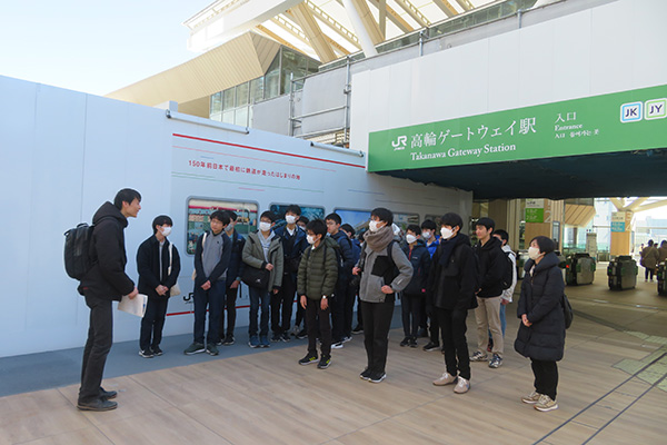 高輪ゲートウェイ駅前で説明を受ける生徒たち。