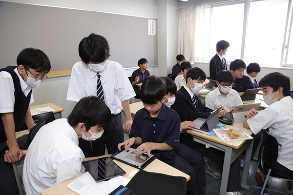 グループワークで活発に意見を交わす生徒たち。資料の年表を確認したり、インターネットで検索したりしながらアイデアを出し合い、意見をまとめてワークシートに記入していきます。