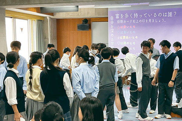 『世界がもし100人の村だったら』を教材に使用することも。世界では狭い土地にどれだけ貧しい人たちが暮らしているのか、輪にしたロープを国土に見立てて、その中に生徒たちが入っていき、人口密度を体感します。