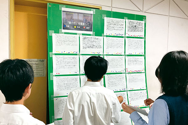 『聲の形』の感想文を読んでシールを貼る生徒たち。教員も、ふだんは物静かな生徒が自分の思いを熱く語っている文章を読んで感動するなど、授業では見ることのできなかった生徒の一面を知るといいます。