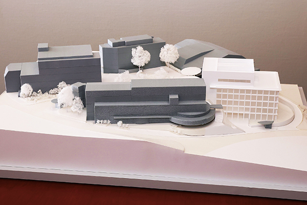 創立50周年を記念して建てられる新校舎の模型（右側の白い建物）。各階には自習や友人との学び合いに利用できるラーニングコモンズが設けられる予定です。