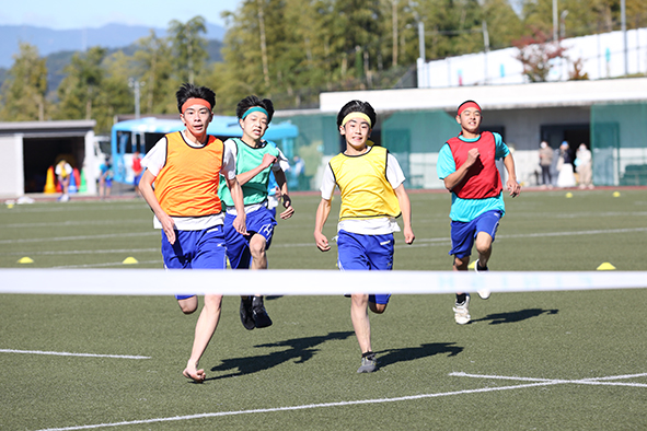 競技の幕開けは、全学年による『100m走』。生徒たちによる実況は、「いい勝負です」「黄色が速すぎ！」「追い上げてます！！」と、どんどんテンションが上がっていく。